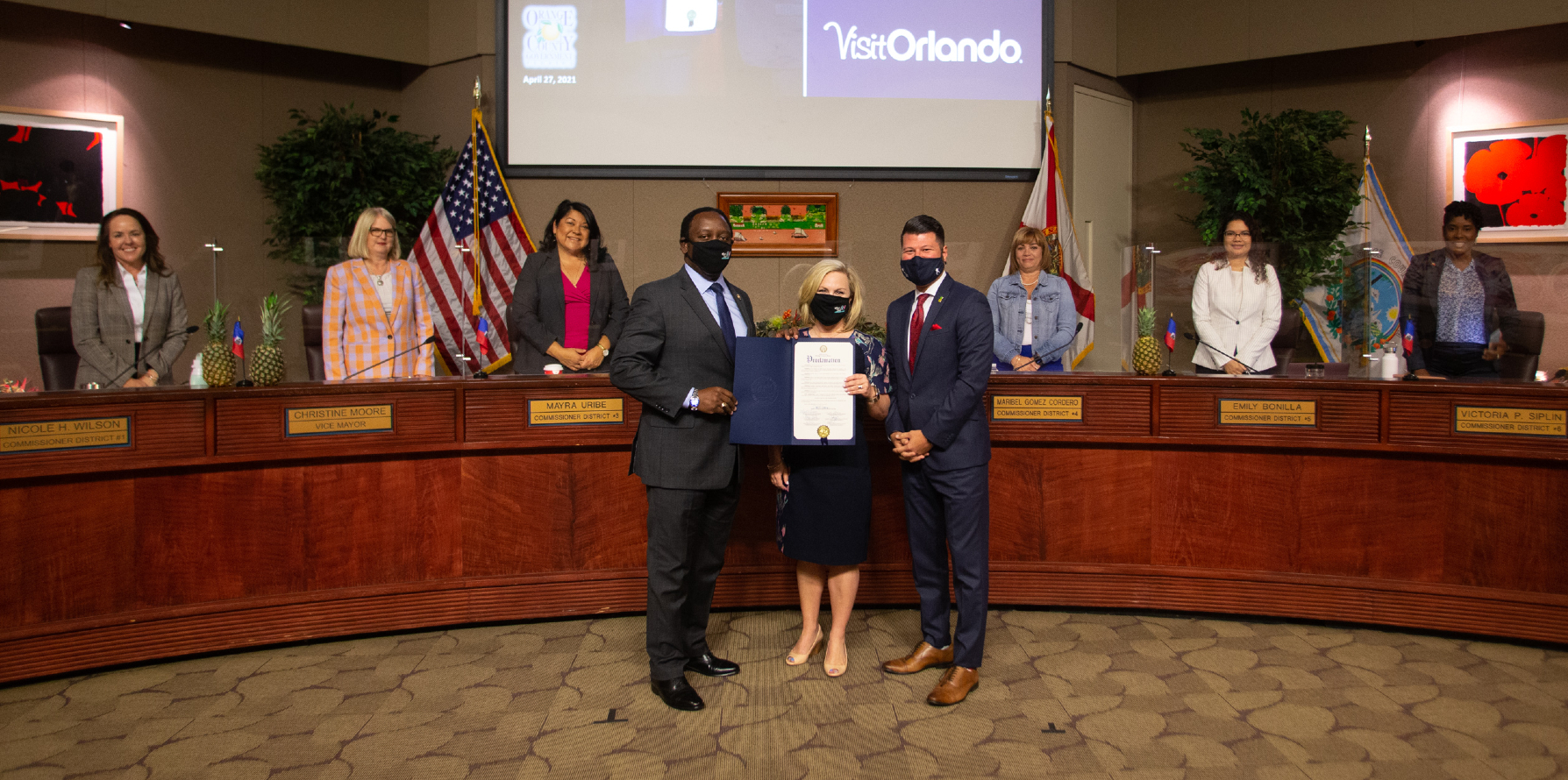 Foreground, from left to right: Mayor Jerry Demings; Casandra Matej, President and CEO of Visit Orlando; Robert Agrusa of the Central Florida Hotel & Lodging Association 